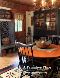 The centre of the room is characterized by three antique trunks, a rustic bench, a green sofa, and a dark armchair. Colonial Dining Room Colonial Dining Room Primitive Dining Rooms Primitive Dining Room
