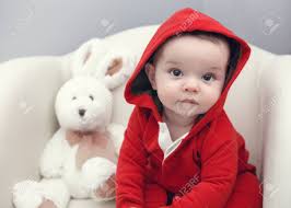 Closeup Portrait Of Cute Adorable Caucasian Baby Boy Girl With Black Brown Eyes In Red Hoodie Shirt Sitting In Chair With Toy Looking Directly In Camera Stock Photo Picture And Royalty Free