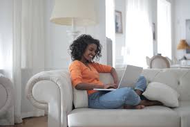Upset woman sitting on couch alone at home side view young woman looking away at window sitting on couch at home. Woman Sitting On White Couch Using Laptop Computer Free Stock Photo