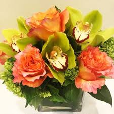 Roses, cumbidium orchids, dianthus, anemones, and variety of greens in a clear glass vase. Brooklyn Florist Flower Delivery By Floral Heights Inc