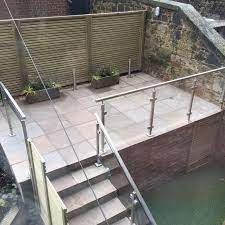 A Raised Patio In Sandstone With Glass Balustrades Patio Balustrade Ideas Patio Remodel Raised Patio