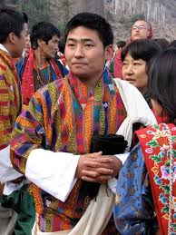 Men, women and children wear traditional clothing made from bhutanese textiles in a variety of colorful patterns. From The Kingdom Of The Thunder Dragon Thunder Dragon Bhutanese Clothing Bhutan