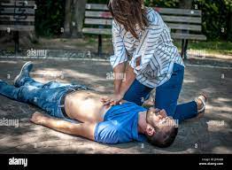 girl making cardiopulmonary resuscitation to an unconscious guy after heart  attack Stock Photo - Alamy