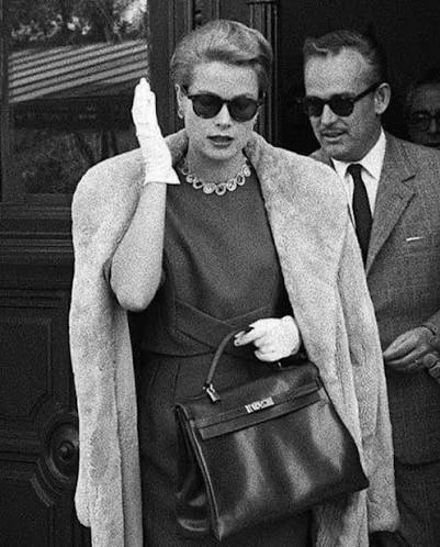 Princess Grace Kelly newly pregnant and trying to hide it from the  paparazzi holds an Hermes bag in front of her baby bump. Hermes then  re-names the large handbag 'The Kelly Bag'. #