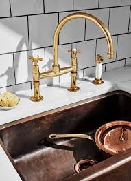 From faucets to shower systems, toilets to bath accessories, gold can help you create your perfect kitchen. Easton Classic Two Hole Bridge Kitchen Faucet Metal Cross Handles And White Porcelain Spray Unlacquered Brass Faucet Kitchen Faucet Brass Kitchen Faucet