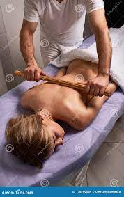 Masseur Fazendo Massagem Japonesa Com Bastões De Bambu No Belo Corpo De Uma  Mulher Nua No Salão Spa. Tratamento De Beleza Imagem de Stock 