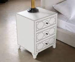 A nightstand is an essential piece of furniture that is functional and helps a bedroom feel finished. White Leather 3 Drawer Nightstand With Brass Nailhead