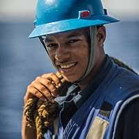 Boatswain's Mate Seamen Daniel Nogal, left, and Lucio Robles take lines off  a pallet of stores sent to the guided-missile destroyer USS Mitscher (DDG  57).