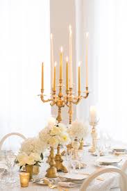 Classic Wedding Reception Table Decor With Tall Gold Candlesticks Lace Table Cloth White O Table Arrangements Wedding Wedding Table Decorations Wedding Table