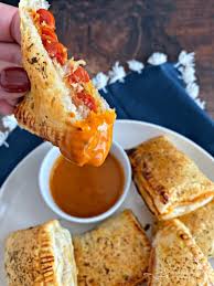 A guy eating a pizza pop. Dorothy S Pizza Pockets Pepperoni Puff Pastry And A Tangy Sauce