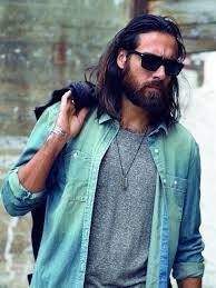black hair wavy hairstyles for men denim shirt grey shirt man with sunglasses kurze haare und bart lange haare manner frisuren langhaar