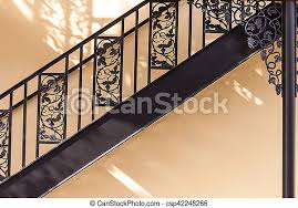 Iron railings, window bars, metal security doors, custom iron work, welding repairs, fencing, driveway gates. Wrought Iron Railing Detail Against Yellow Wall Canstock