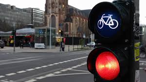 Dusseldorf, Germany - February 28, 2020. traffic light for bicycles  close-up with a busy city in the background at a crossroads in Germany.  Cyclists wait for a traffic light to cross the