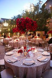 A lush red rose and greenery wedding arch with gold and white chairs make up a refined ceremony space. Red Rose Filled Wedding Day Wedding Centerpieces Red Wedding Wedding Decorations