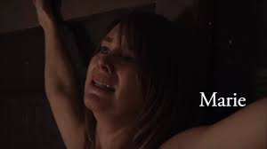 Mujer desnuda sufriendo en la cruz.