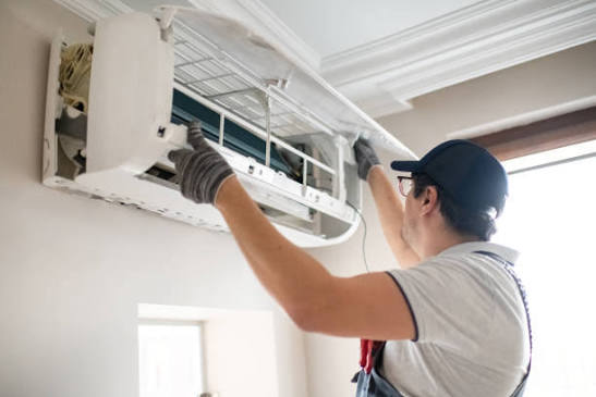AC technician repairing an air conditioning unit