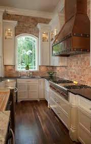 When you combine white kitchen cabinets with a white or very light colored stone countertop (be it marble, granite, or soapstone) your kitchen becomes a serene continuously flowing room. This Kitchen Brick Tall White Cabinets Professional Grade Appliances Arched Window Hardwood Floors Brick Wall Kitchen Exposed Brick Kitchen Brick Kitchen