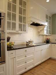The natural wood finish on floors and the island cabinetry introduce warmth and texture. Glass Front Kitchen Cabinets Traditional Kitchen Alethea Sadowski