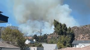 Fire crews battle the Walnut Fire on a hillside above Burbank