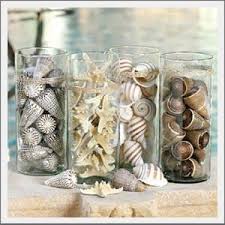 Photo display ideas for beach memories decorate jars & bottles beach style Glass Hurricanes Filled With Sealife Simple And Uncluttered Like Life At The Beach Beach Decor Cottage Christmas Decorating Beachy Decor