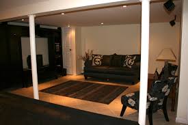Its clean finish can be painted to match the other walls, providing a continuity that helps the columns fade into the background instead of becoming focal points. An Outstanding Application Of Pole Wrap Used To Cover Two Lally Columns In An Artfully Designed Basement Pole Wrap Column Covers Finishing Basement