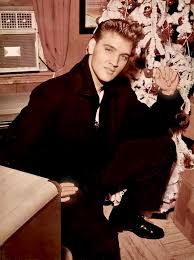 Elvis Presley by his Christmas tree at Graceland. (1960)
