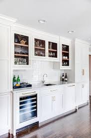 Glass Cabinets Over A Square Wet Bar With Sink Featuring White Linear Subway Tiles With A Glossy Finish Kitchen Wet Bar Kitchen Bar Design Wet Bar Cabinets