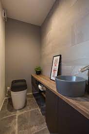 落ち着いた雰囲気の中にこだわりを効かせたモダンハウス 施工実例 愛知 名古屋の注文住宅はクラシスホーム 広々としたトイレ空間 カウンターはオーダーで製作 手洗いボウルの色にもこだわりました 壁面には消臭効果のあるタイルを使用 トイレのアイデア トイレ