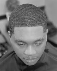 This haircut combines the sleek, modern look of a low bald taper with the  stylish, textured appearance of 360 waves, making it a popular choice for  those seeking a fresh and refined