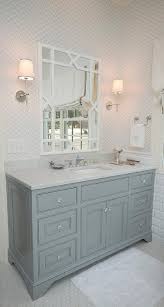 Blue and gray bathroom features walls painted gray, farrow & ball cornforth, lined with a blue grey vanity painted benjamin moore french beret topped with italian white carrera marble under a silver leaf beveled mirror illuminated by mirrored sconces alongside a carrera hex floor Gray Washstand With White Trellis Mirror Transitional Bathroom Elegant Bathroom Gray Tile Bathroom Floor Bathroom Floor Tiles