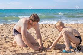Vater Und Sohn Spielen Im Sommer An Einem Sonnigen Tag Am Strand Im Sand.  Schöne Ferien Mit Der Familie Am Strand. Lizenzfreie Fotos, Bilder und  Stock Fotografie. Image 187619869.