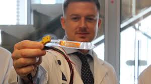 A Swansea doctor who lost both parents to cancer has invented a device  which might have helped them