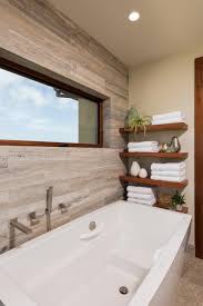 It resembles marble because of its shiny reflective surface. Modern Floating Shelves Over White Bathtub With Neutral Travertine Wall Tile Hgtv