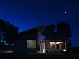 Although the house is one gabled form, protected outdoor spaces are carved out of the main volume and extended on either end, where perforated siding adds texture and provides covered porches with privacy and protection from the elements. Dunn Hillam S Dogtrot House Centres Around An Open Air Corridor