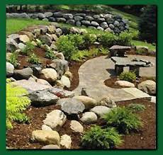 The Natural Touch Landscaping And Lawn Care Outdoor Improvements Hillside Landscaping Landscaping With Boulders