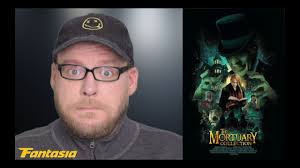 An elderly mortuary caretaker, played by a delightfully ghoulish clancy brown, is approached by a young woman looking for a job as his assistant; The Mortuary Collection Movie Review Fantasia Festival 2020 Spoiler Free Youtube