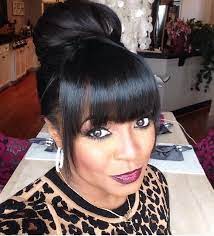 Pull half your hair up into a small bun above straight bangs and your look is ready to go. Black Hair Bun With A Bang