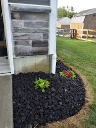 Dig a hole slightly larger than the rock and fill in the dirt after setting the rock in place. Lava Rock Landscaping Prettying Up The Side Of The House With The Garbage Can