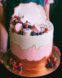 Rose Gold And Pink Themed Cake With Gold Leaf Accents Macarons Berries And Flower Petals Themed Cakes Cake Rose Gold Cake