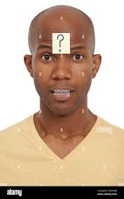 So many unanswered questions...An African-American man with a question mark  stuck to his forehead Stock Photo