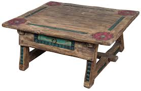 This piece is painted wood with polychrome floral decor; Carved Antique Painted Wood Ranch Coffee Table