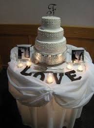 If you have multiple cakes, you can place them on a stand one above another, put them on branches of a big tree piece, or even hang one above another. Cake Table Decor Simple Cute Couple Framed Photos Candles Flowers And Our Ini Wedding Cake Table Decorations Wedding Cake Table Cake Table Decorations
