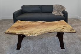 Each floating coffee table features a live edge wood slab supported by a simple table base. Redwood Live Edge Coffee Table Macik Custom Woodworking