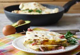 Servite uova strapazzate con avocado, pane di segale tostato, insalata di pomodori e, se vi poi un uovo al padellino, il prosciutto crudo di cui sopra, una tortilla o una piadina: Piadina Uova E Avocado