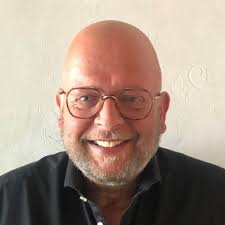 Wat ga je doen?", vroeg de vriendelijke en opgeruimde medewerkster van de  Kamer van Koophandel. Ik was bruut van haar gescheiden door een plexiglas  scherm. De flesjes desinfectiemiddel maakte het…