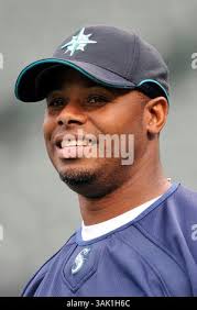 Ken Griffey Jr. of the Seattle Mariners, center, sits in the dugout next to  manager Lou Panella, right, during the first inning of game in Seattle  against Kansas City, June 14, 1995. (