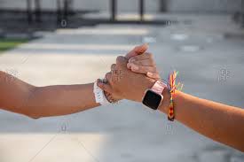 Crop hands of females with pink and white modern smartwatches giving high  five and shaking hands on street with blurred background stock photo -  OFFSET