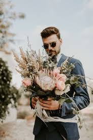 Each wedding couple has its own matching design, something that resonates with the style and personality of the happy newlyweds. Green Gold Blush Cyprus Destination Wedding With A Tunnel Of Lights 100 Layer Cake Protea Wedding Wedding Bouquets Pink Blush Wedding Flowers