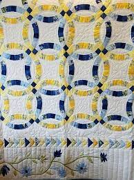 This Stunning Queen Wedding Ring Quilt Features A Border Of Blue And Yellow Appliqued Flowers Around The We Double Wedding Ring Quilt Wedding Ring Quilt Quilts