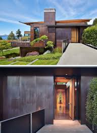 The exterior of the house is covered in black fibre cement panels with matching black battens that create dimension and define the window locations. Dark Stained Cedar Siding And Copper Panels Cover The Exterior Of This Mercer Island House
